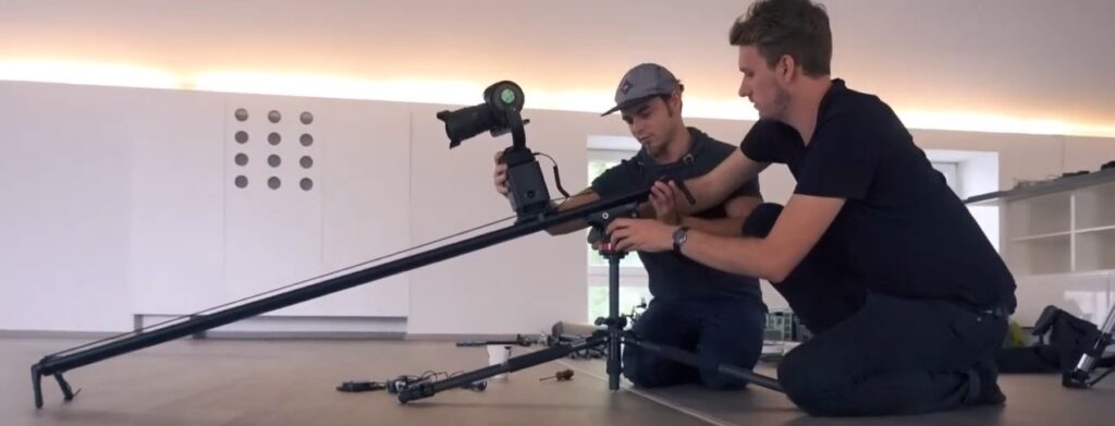2 Menschen beim Aufbau einer Filmkamera
